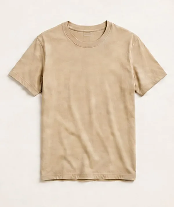 A flat-lay photograph of a beige cotton t-shirt on a cream studio backdrop
